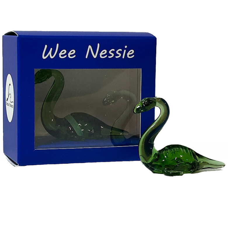 Green glass figurine of a mythical creature in front of a blue box labeled 'Wee Nessie'.